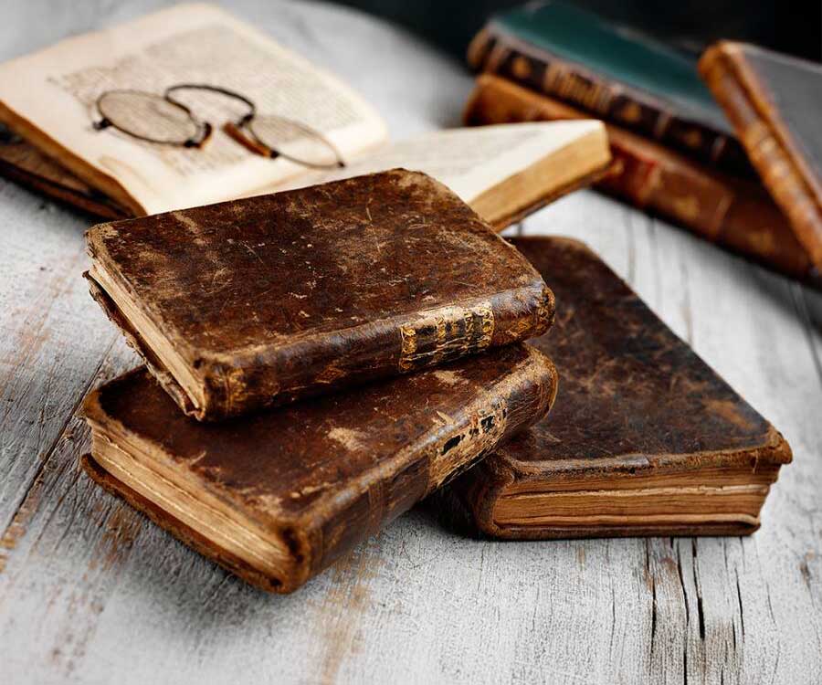 Livres anciens couverture cuir abîmées empilés